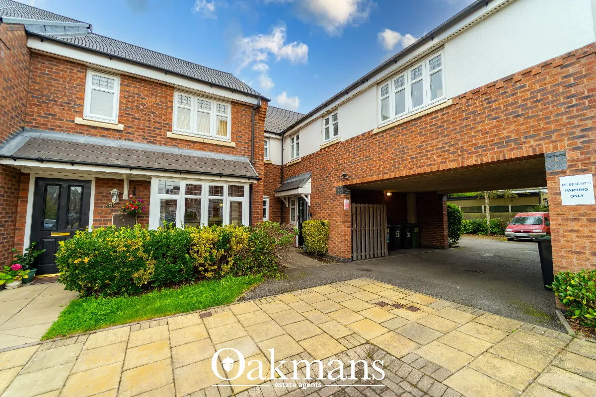 A modern brick apartment block with a covered archway to residents' parking on Cardinal Close