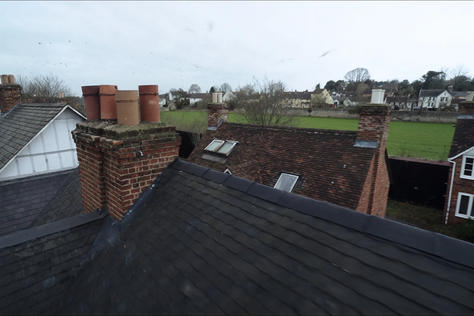 View across the rooftops and chimneys a surveyor inspects during a RICS home survey
