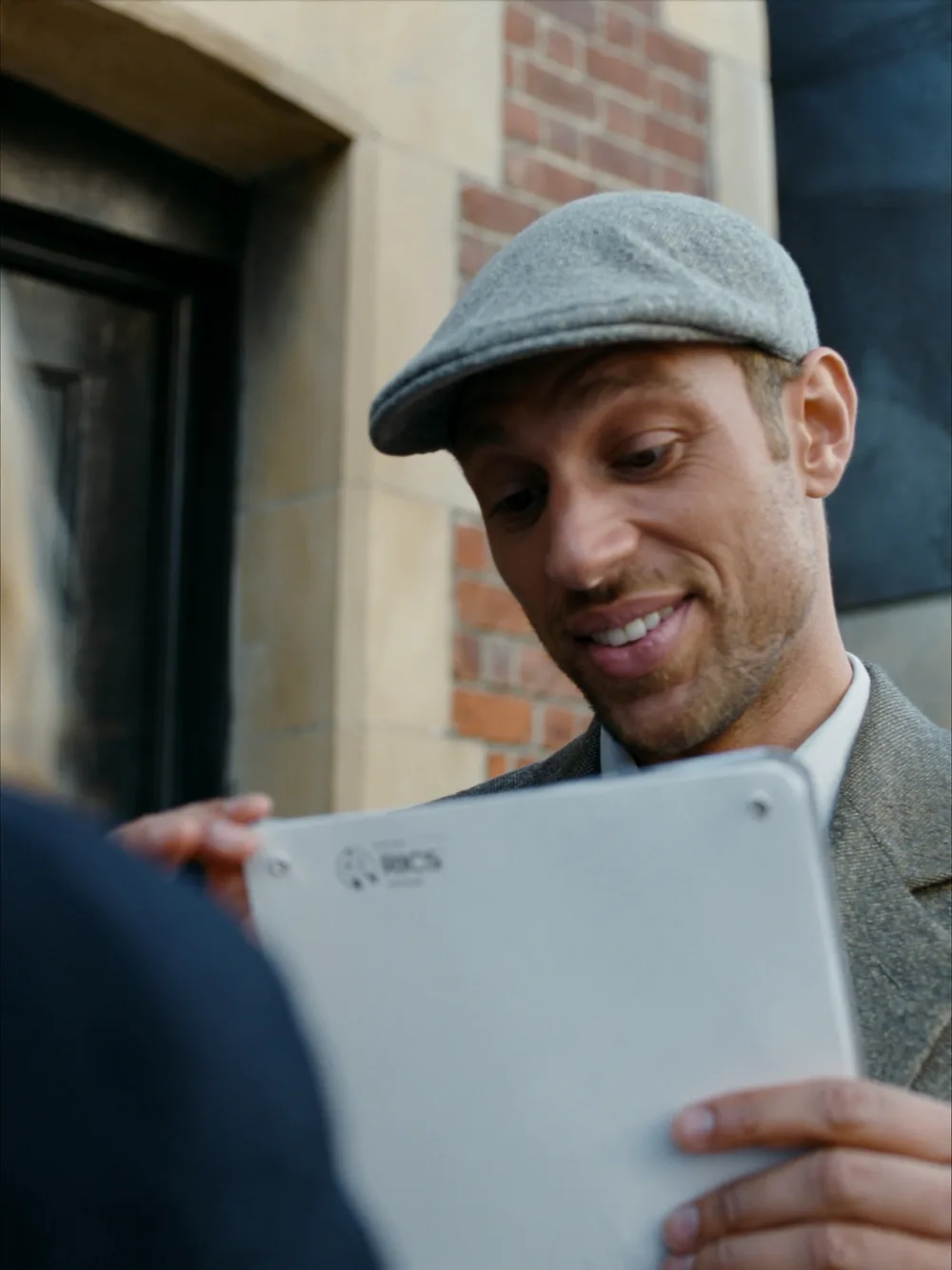 RICS surveyor checking a survey checklist at the front door