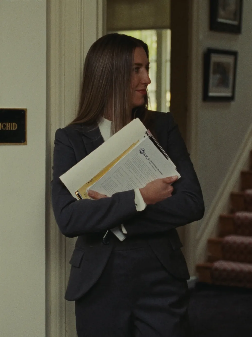 Chartered surveyor holding RICS report documents inside a period property