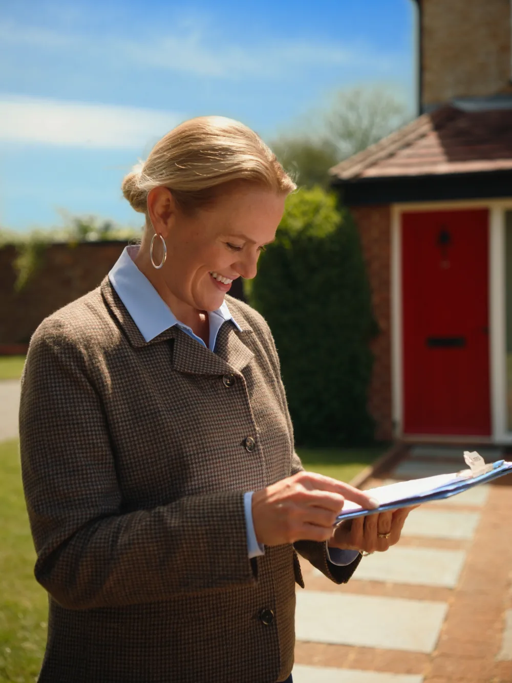 RICS surveyor reviewing inspection notes outside a home