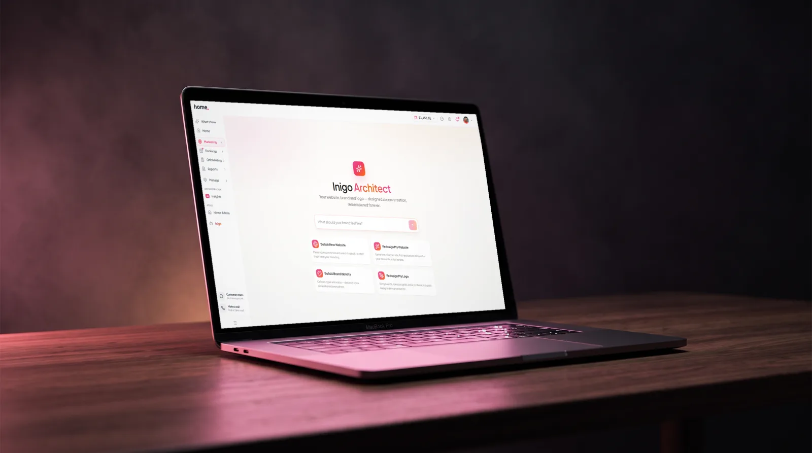 The home.co.uk Website Studio open on a MacBook on a wooden desk in soft rose evening light